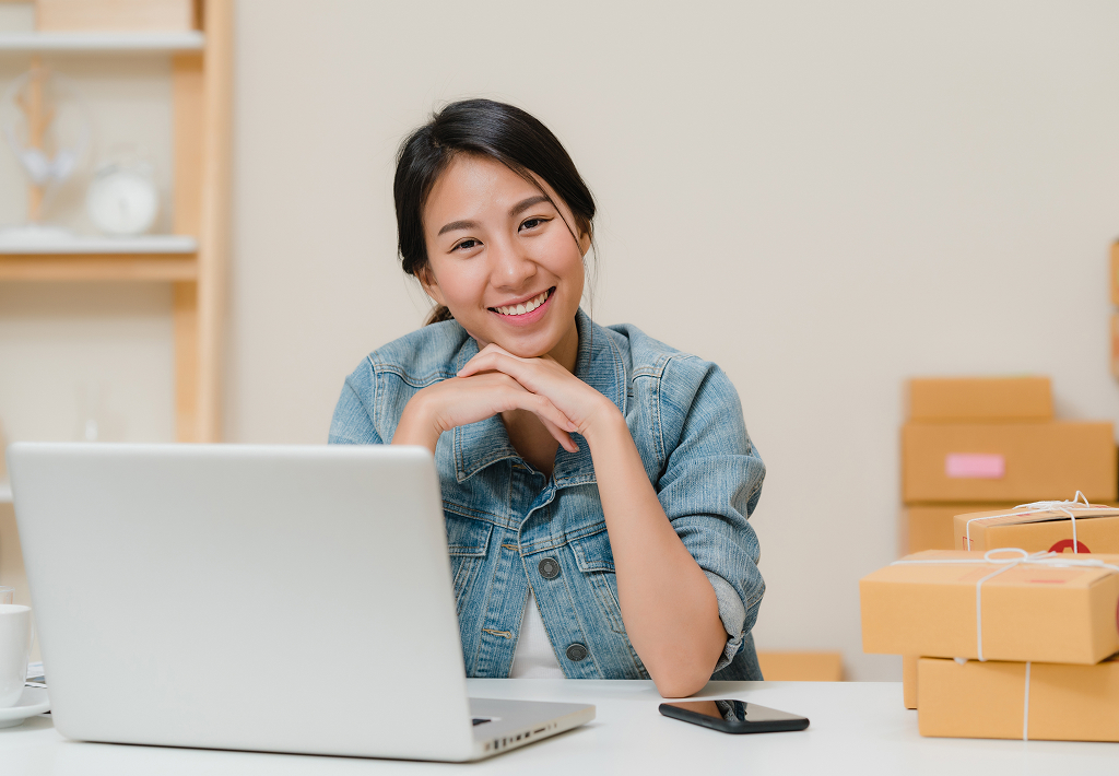 Happy businesswoman smiling at the camera while working from her home office